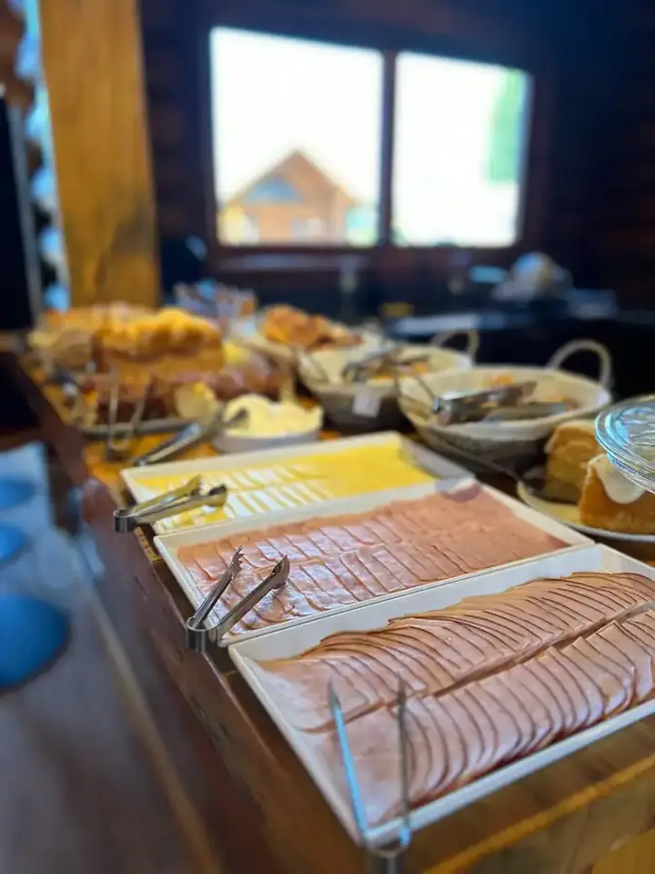 Café, suco, frutas e quitutes servidos no café da manhã da Pousada Maple